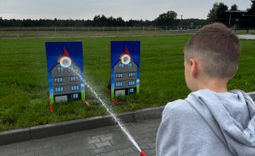 Dziecko celujące strumieniem wody do celu